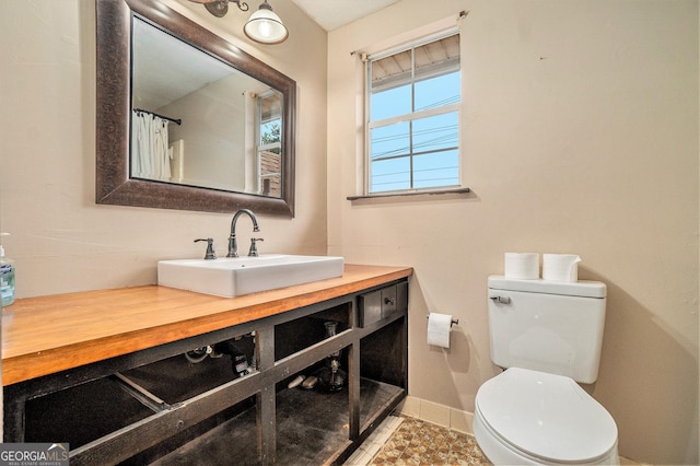full bath featuring vanity, toilet, and baseboards