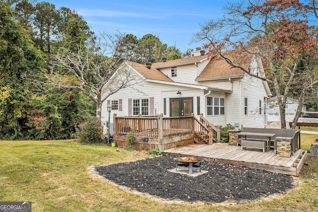 rear view of property with a deck, an outdoor fire pit, french doors, a yard, and roof with shingles