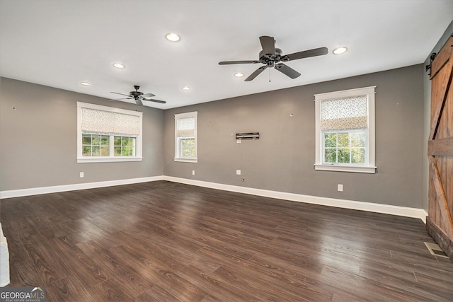 unfurnished living room featuring a barn door, recessed lighting, visible vents, and plenty of natural light
