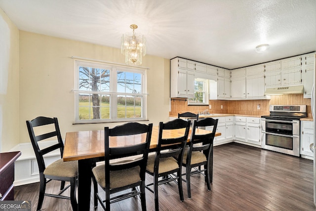 dining room with dark wood finished floors and an inviting chandelier
