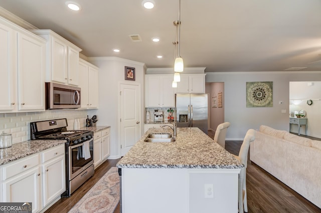 kitchen featuring tasteful backsplash, a sink, dark wood finished floors, baseboards, and appliances with stainless steel finishes