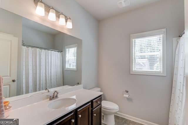 full bathroom featuring baseboards, toilet, and vanity