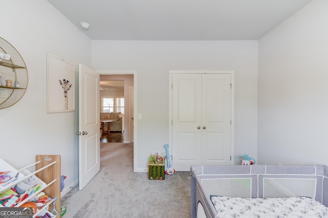 bedroom with a closet, baseboards, and light carpet