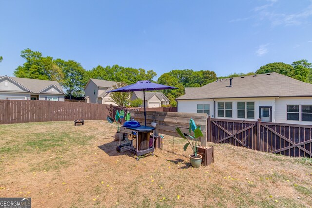 view of yard featuring a fenced backyard and a fire pit