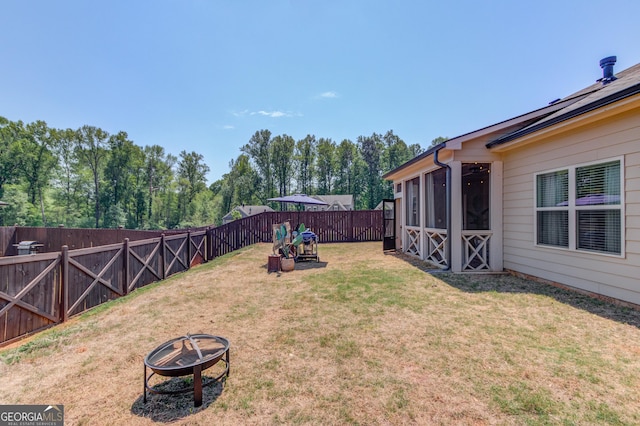 view of yard featuring a fire pit and a fenced backyard