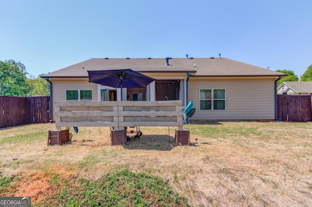 rear view of property with a yard and a fenced backyard