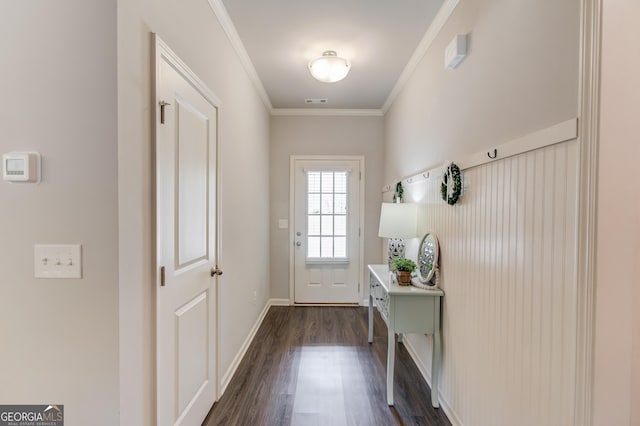 doorway to outside with baseboards, dark wood-type flooring, and ornamental molding