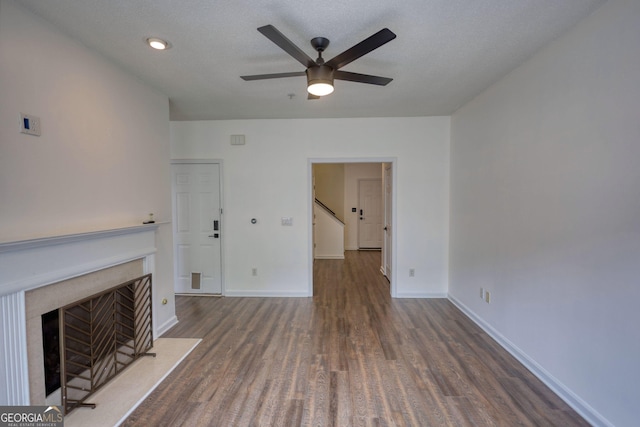 unfurnished living room with a fireplace with flush hearth, recessed lighting, wood finished floors, baseboards, and ceiling fan
