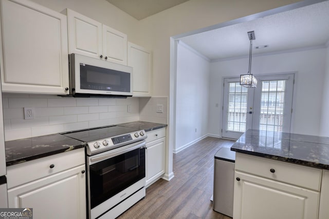 kitchen with white cabinets, dark wood finished floors, white microwave, backsplash, and stainless steel range with electric stovetop