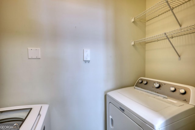 washroom featuring washing machine and clothes dryer and laundry area