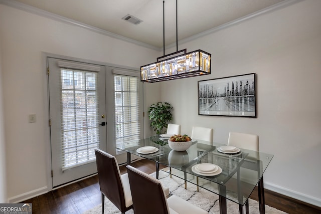 dining room featuring baseboards, crown molding, dark wood-type flooring, and visible vents