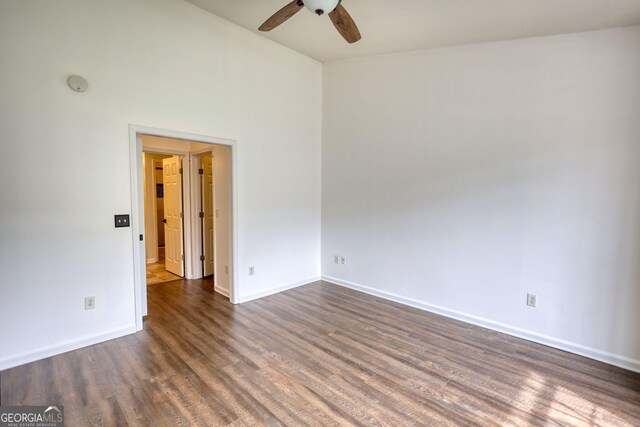 spare room featuring dark wood-type flooring, baseboards, and ceiling fan