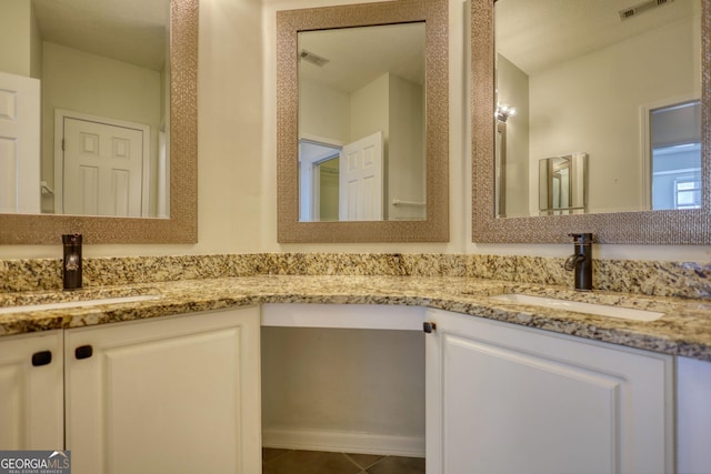 bathroom featuring double vanity, visible vents, and a sink