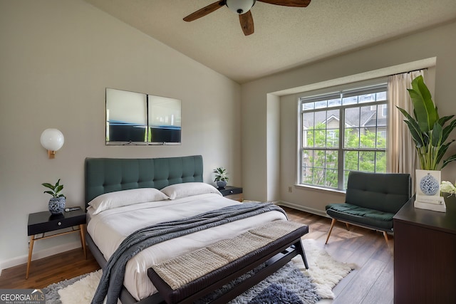 bedroom with vaulted ceiling, baseboards, and wood finished floors