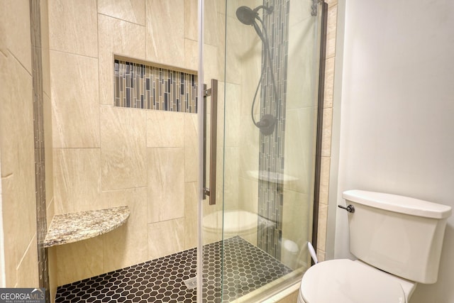 bathroom featuring toilet and a stall shower