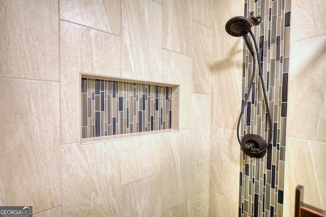 interior details featuring a tile shower