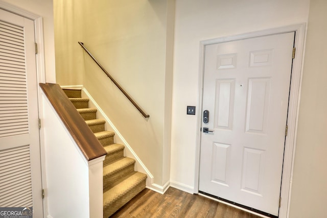 entrance foyer featuring baseboards, stairs, and dark wood-style floors