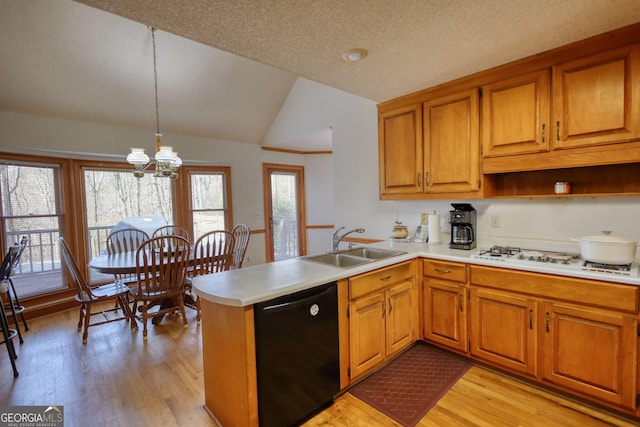kitchen featuring a sink, white gas stovetop, light wood-type flooring, black dishwasher, and a peninsula