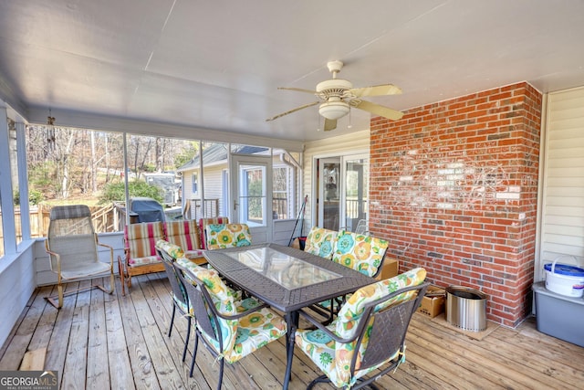 sunroom featuring outdoor dining area and a ceiling fan