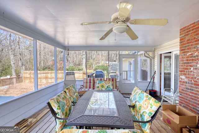 sunroom featuring a ceiling fan and outdoor dining area