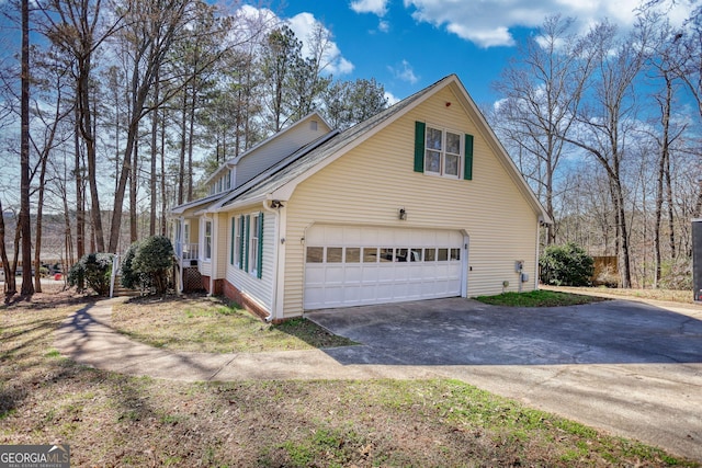view of side of home with driveway and a garage