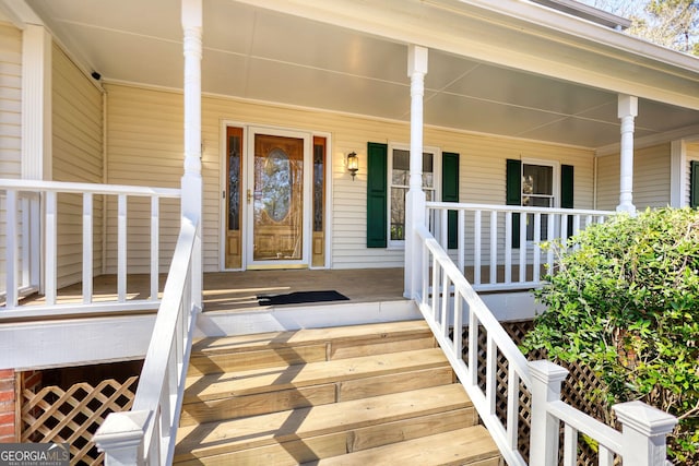 view of exterior entry featuring covered porch