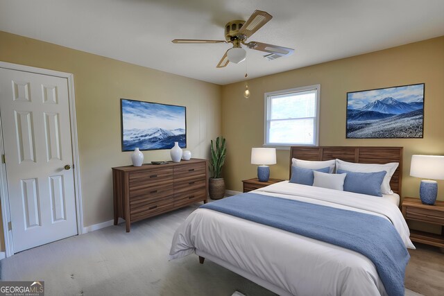 bedroom featuring visible vents, light carpet, a ceiling fan, and baseboards