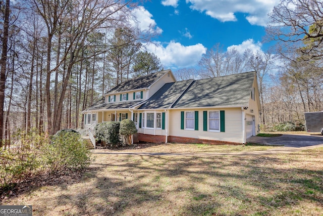 traditional home featuring a porch, driveway, and a front yard