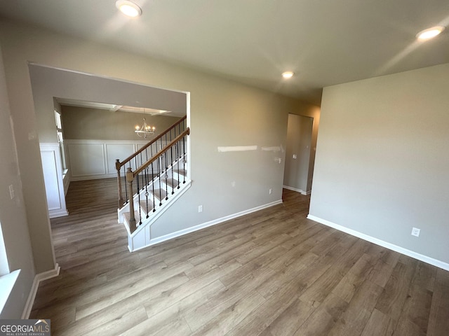 165 Jodi Pl, Locust Grove, GA 30248 - spare room featuring stairs, baseboards, wood finished floors, and a notable chandelier