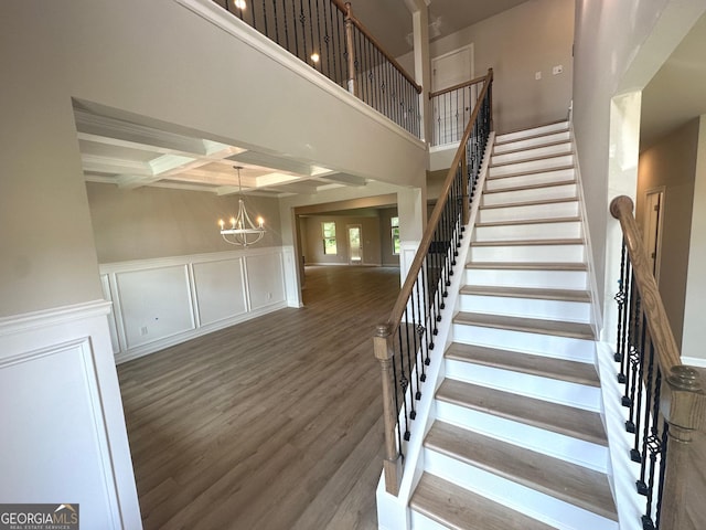 165 Jodi Pl, Locust Grove, GA 30248 - staircase with a decorative wall, wood finished floors, a chandelier, beamed ceiling, and coffered ceiling