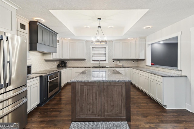 kitchen with dark wood-style flooring, tasteful backsplash, stainless steel appliances, and a sink