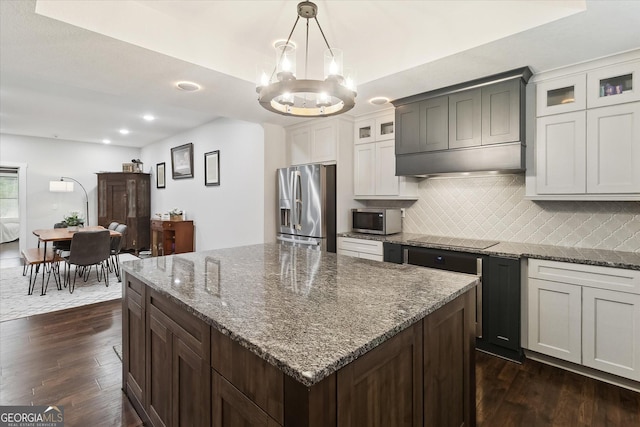 kitchen with custom exhaust hood, a notable chandelier, backsplash, appliances with stainless steel finishes, and dark wood-style floors