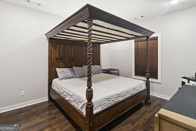 bedroom featuring baseboards, wood finished floors, and visible vents