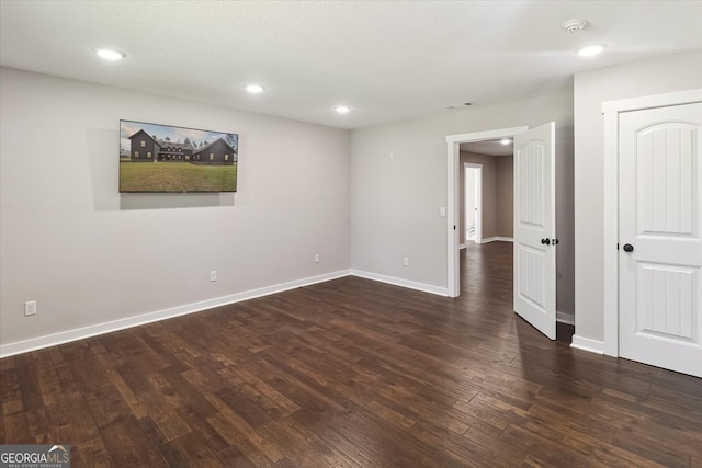 unfurnished room featuring baseboards, dark wood-style flooring, visible vents, and recessed lighting