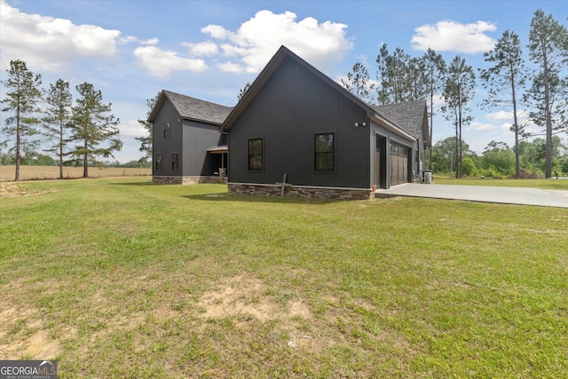 view of side of property featuring a garage, driveway, roof with shingles, and a lawn