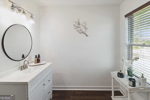 bathroom with wood finished floors, a wealth of natural light, vanity, and baseboards