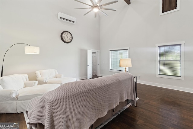 bedroom featuring baseboards, wood finished floors, an AC wall unit, and a high ceiling