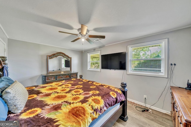 bedroom featuring ceiling fan, light wood-style flooring, and ornamental molding