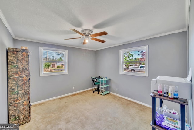recreation room featuring baseboards, carpet flooring, ceiling fan, and crown molding