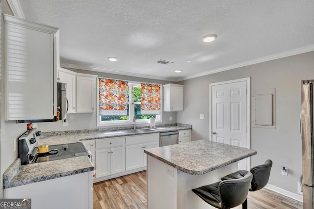 kitchen featuring a kitchen breakfast bar, light wood-type flooring, stainless steel appliances, ornamental molding, and visible vents