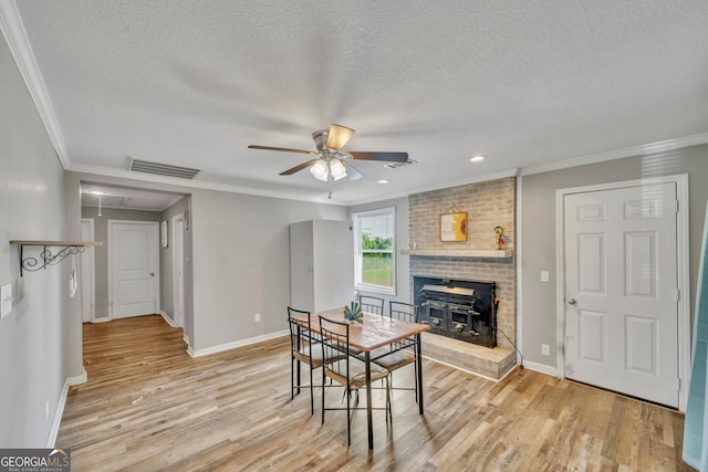 dining room with attic access, visible vents, light wood finished floors, and ceiling fan