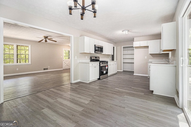 20 King Pl, Stockbridge, GA 30281 - kitchen with open floor plan, baseboards, white cabinetry, and appliances with stainless steel finishes