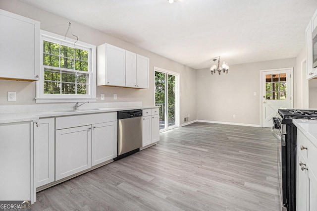 20 King Pl, Stockbridge, GA 30281 - kitchen with light wood finished floors, white cabinets, a sink, a notable chandelier, and appliances with stainless steel finishes