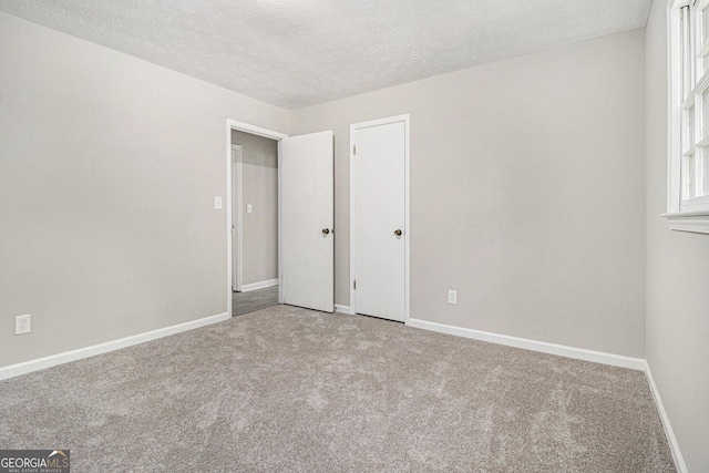 20 King Pl, Stockbridge, GA 30281 - unfurnished bedroom with baseboards, carpet, and a textured ceiling