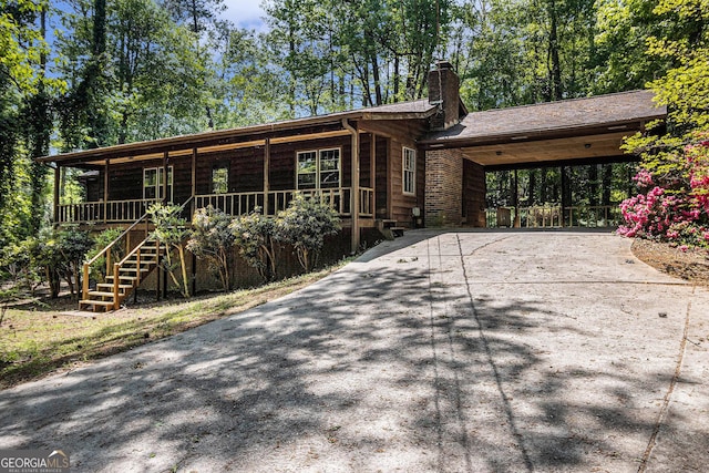 20 King Pl, Stockbridge, GA 30281 - view of front of property featuring a chimney, driveway, covered porch, an attached carport, and stairs
