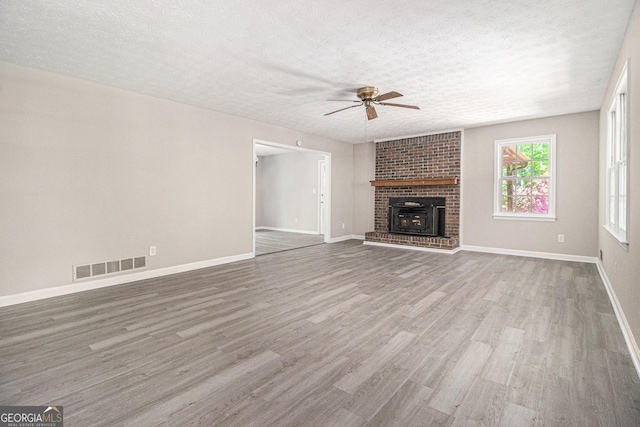 20 King Pl, Stockbridge, GA 30281 - unfurnished living room with a textured ceiling, baseboards, visible vents, wood finished floors, and ceiling fan