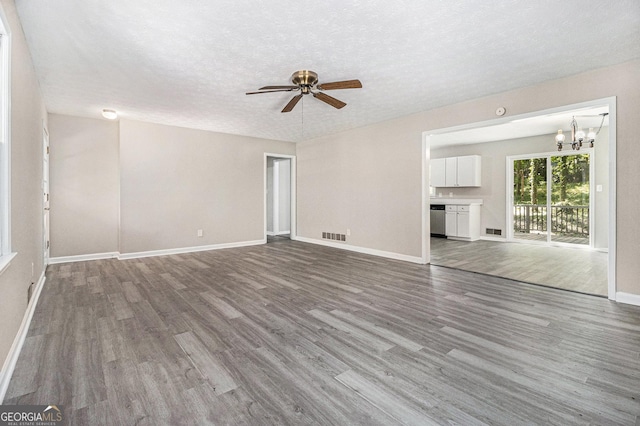 20 King Pl, Stockbridge, GA 30281 - unfurnished living room with wood finished floors, baseboards, and ceiling fan with notable chandelier