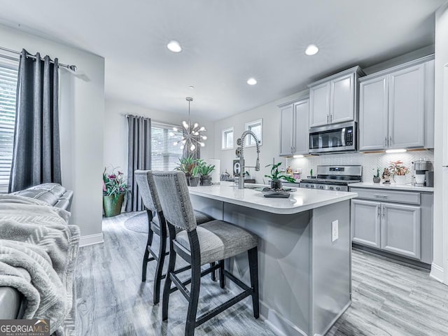 130 Maple Creek Way, Woodstock, GA 30188 - kitchen featuring open floor plan, a kitchen breakfast bar, recessed lighting, light countertops, and appliances with stainless steel finishes