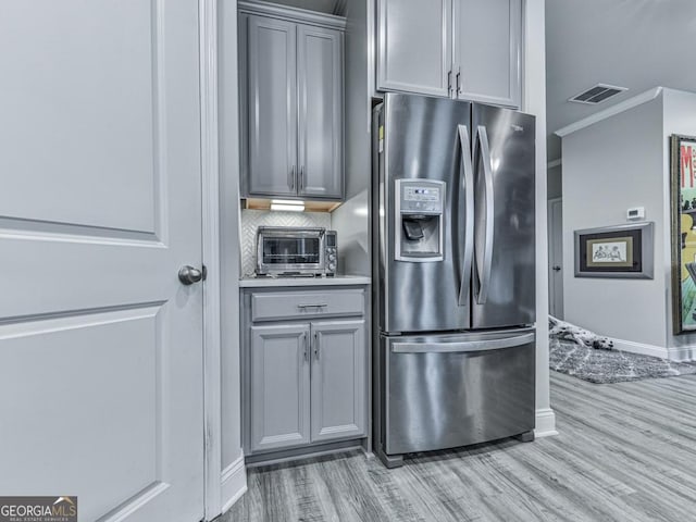 130 Maple Creek Way, Woodstock, GA 30188 - kitchen featuring stainless steel fridge, light wood finished floors, visible vents, baseboards, and gray cabinetry