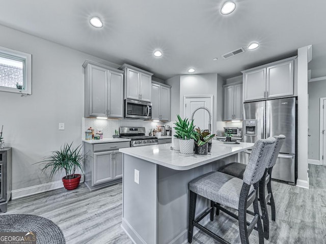 130 Maple Creek Way, Woodstock, GA 30188 - kitchen featuring visible vents, light wood-style flooring, gray cabinetry, and stainless steel appliances